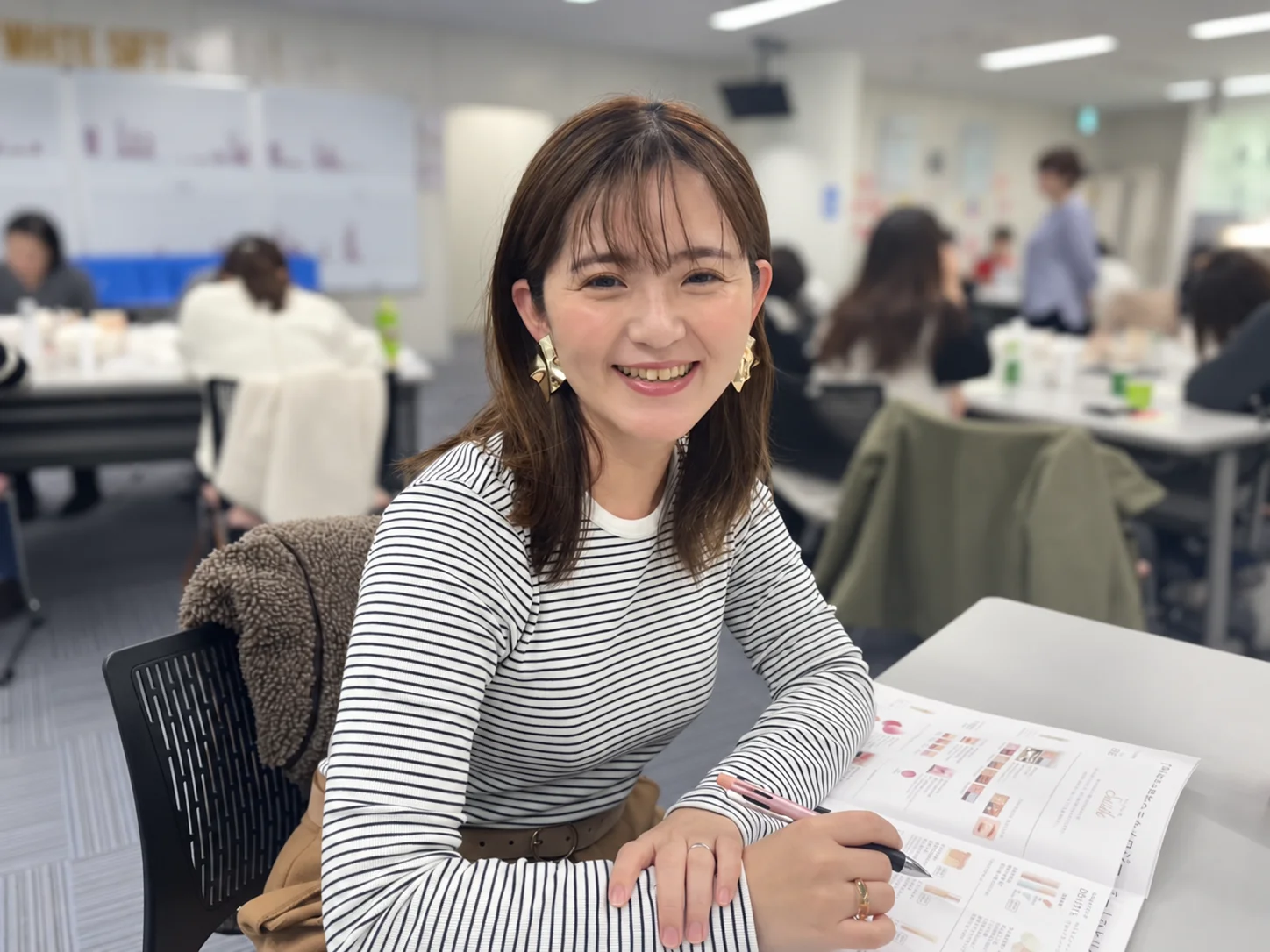 英語の教材を広げ、ペンを手にする伴さおり